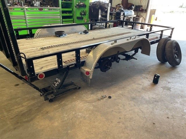 A trailer is sitting on the ground in a garage