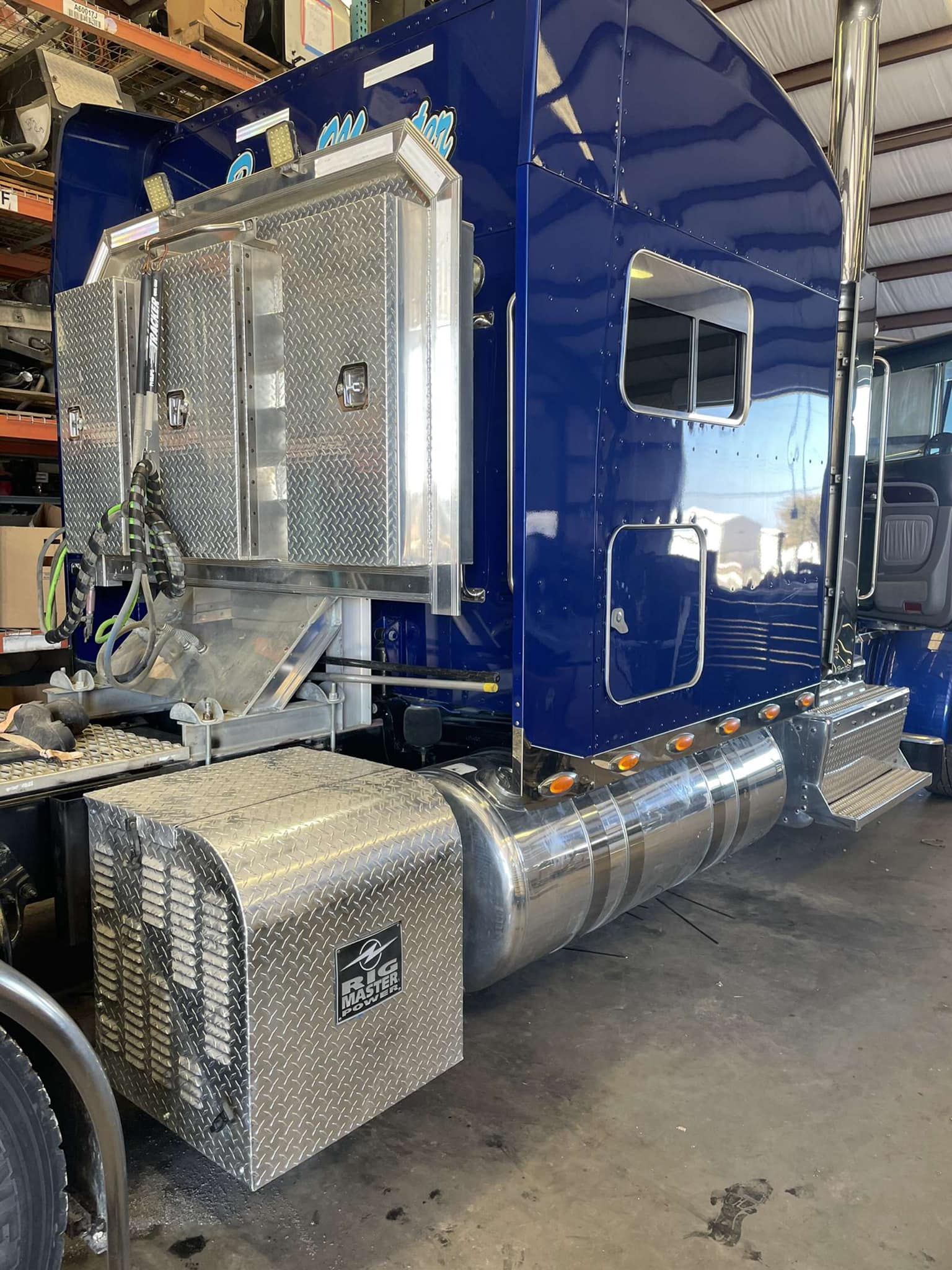 a blue semi truck is parked in a garage.