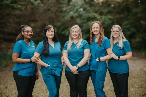 A group of women in scrubs are posing for a picture.