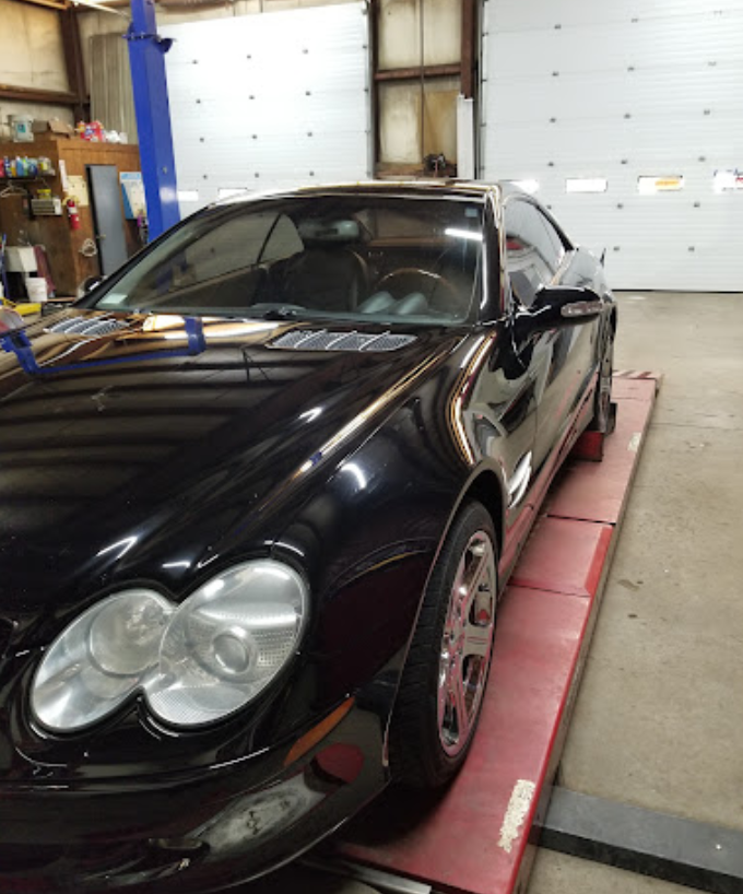 A black car is on a lift in a garage