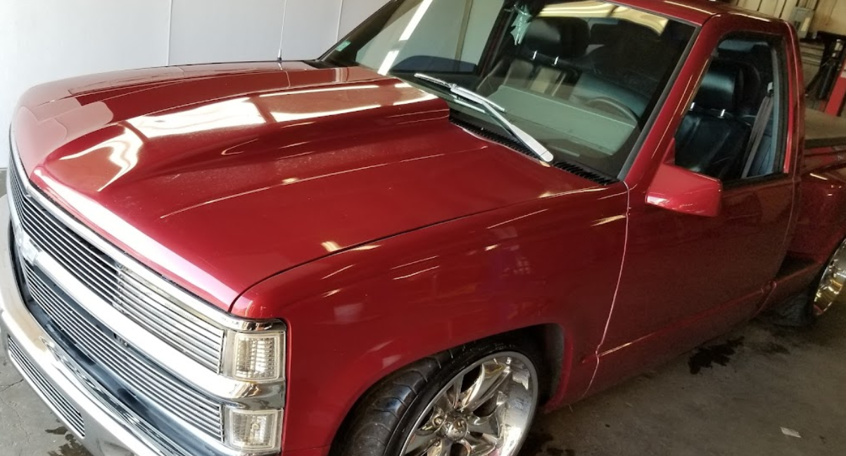 A red truck is parked in a garage.