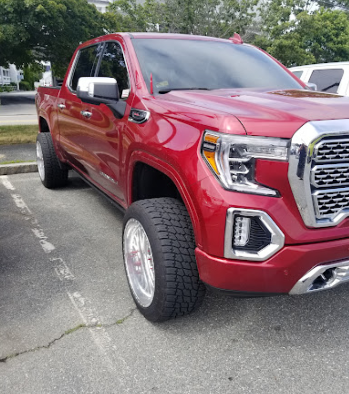 A red truck is parked in a parking lot