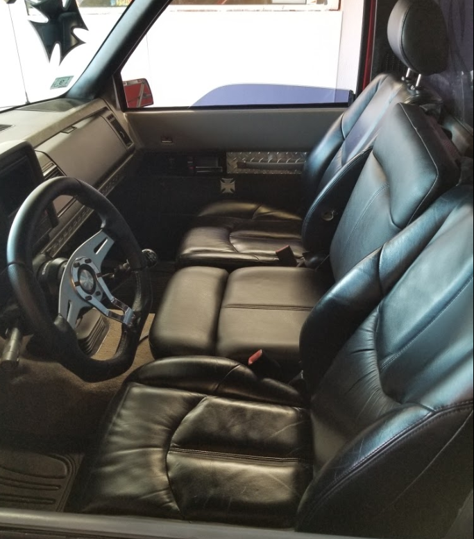 The inside of a car with black leather seats and a steering wheel