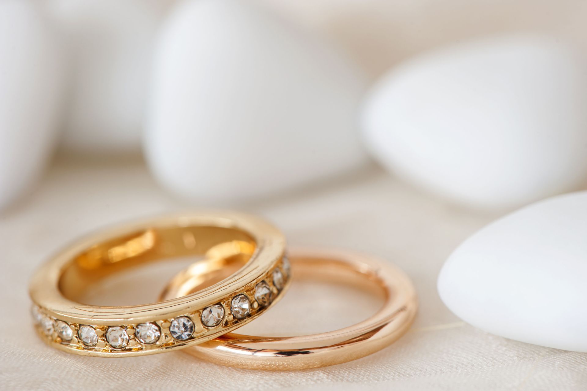 Gold and rose gold rings with a diamond band on a soft white background