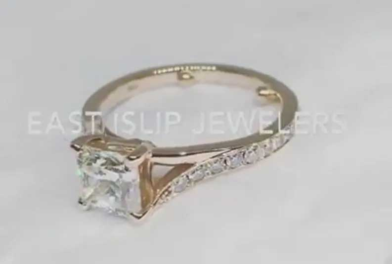 Diamond engagement ring with a square center stone and side stones on a light background