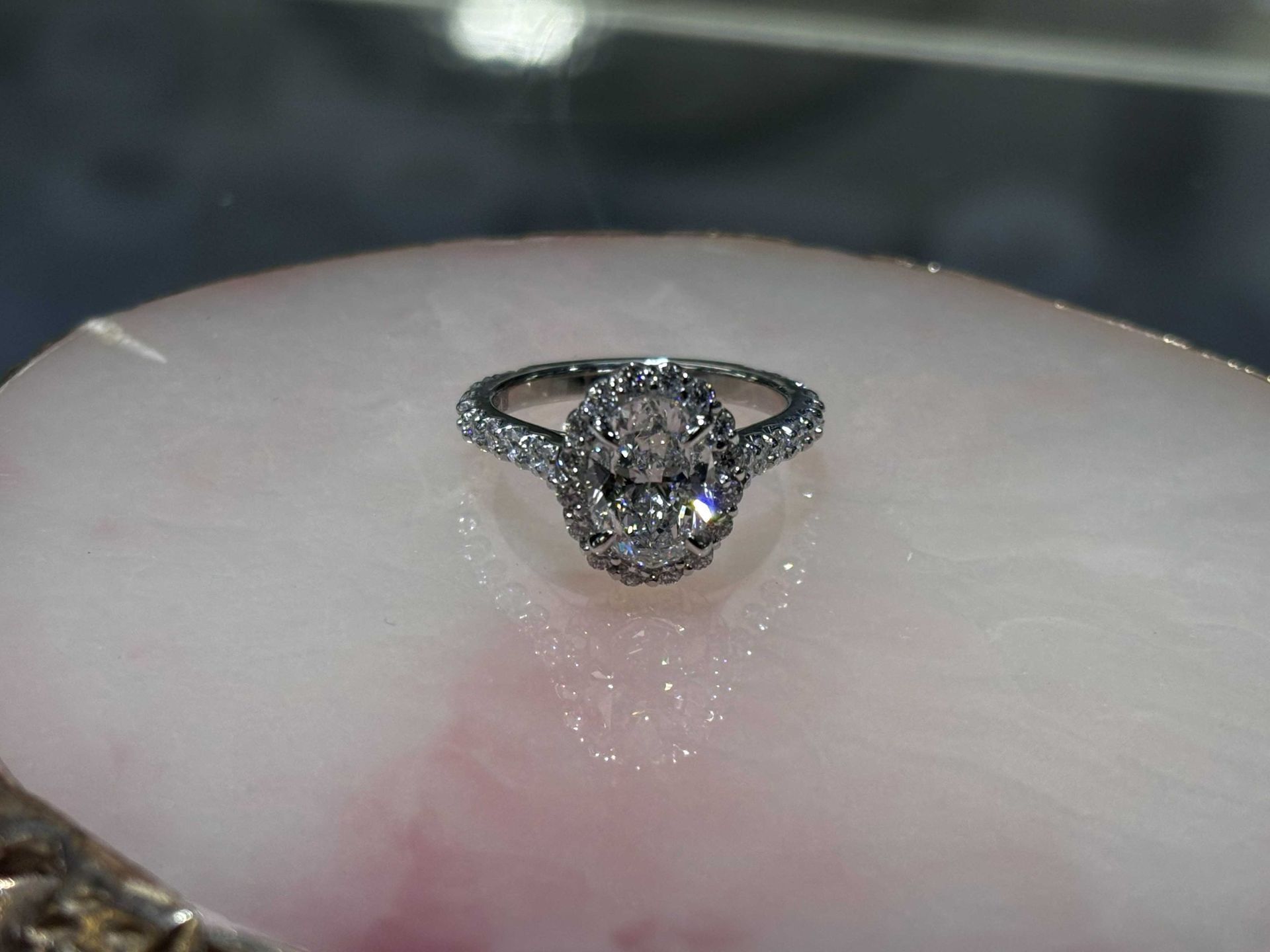 A silver diamond ring resting on a pale finger, viewed close up.