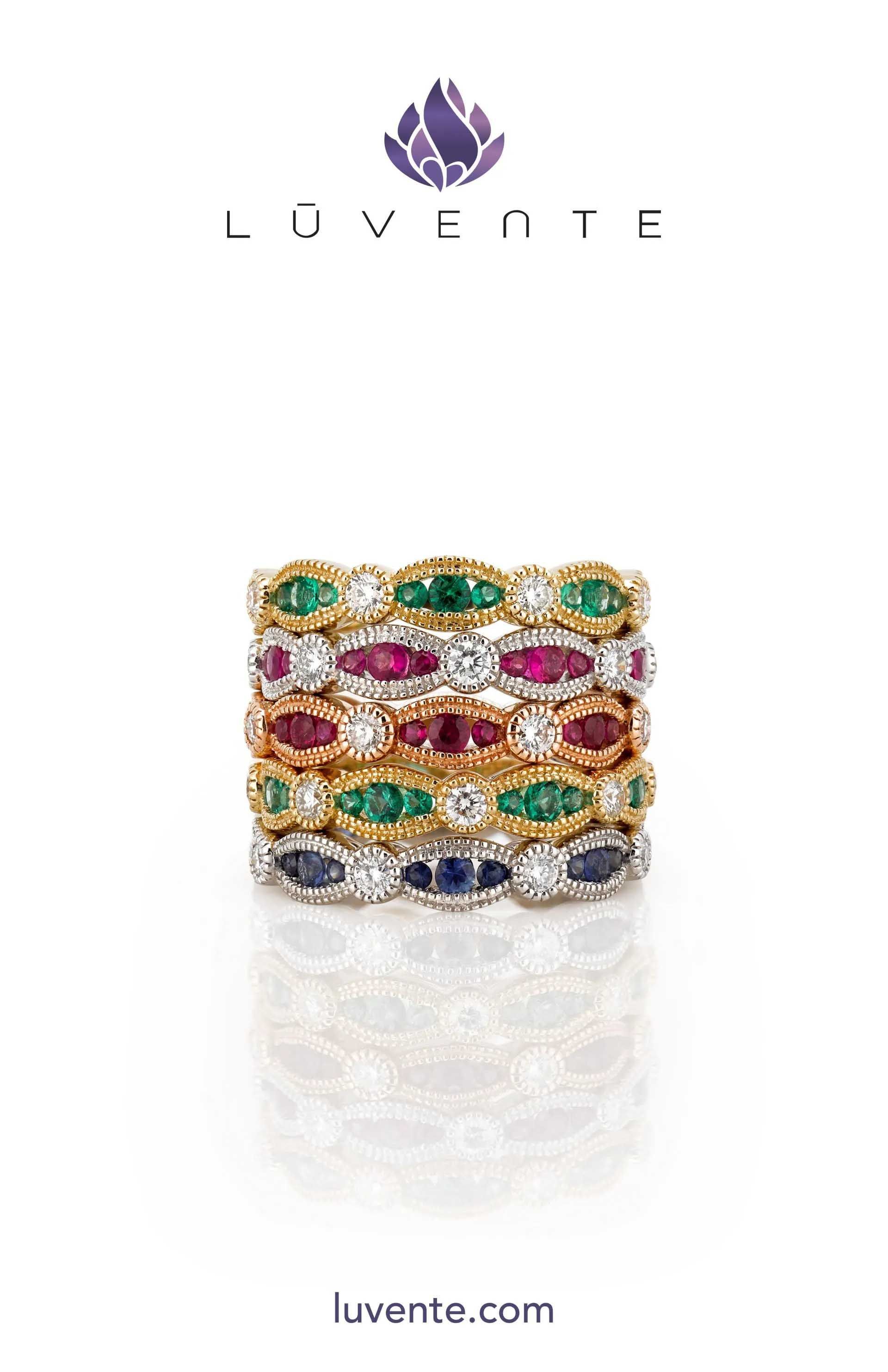 Multicolor gemstone ring with gold bands on white background, Luvente logo and website above and below