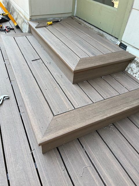 A wooden deck with stairs leading up to a door.