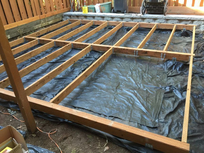 A wooden frame is sitting on top of a black tarp.