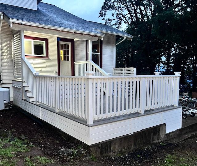 A white house with a white porch and stairs