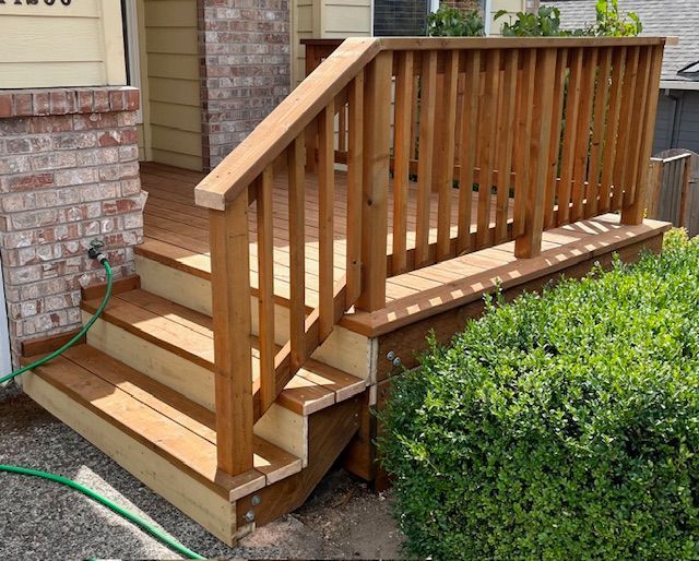 A wooden deck with stairs and a green hose next to it.