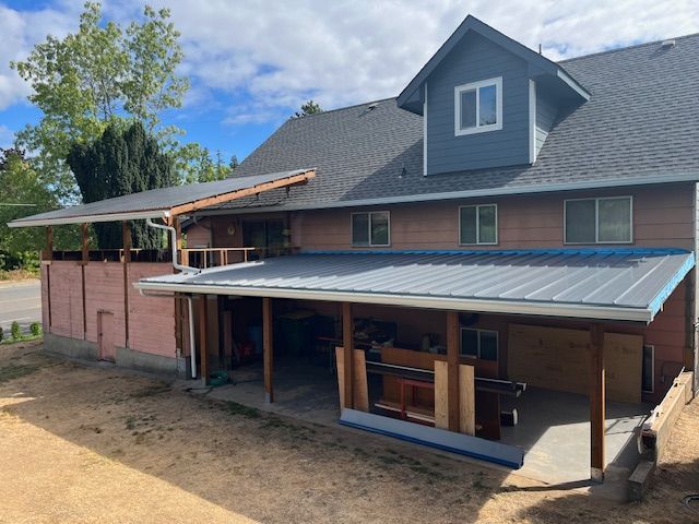 A brick house with a metal roof and a porch.