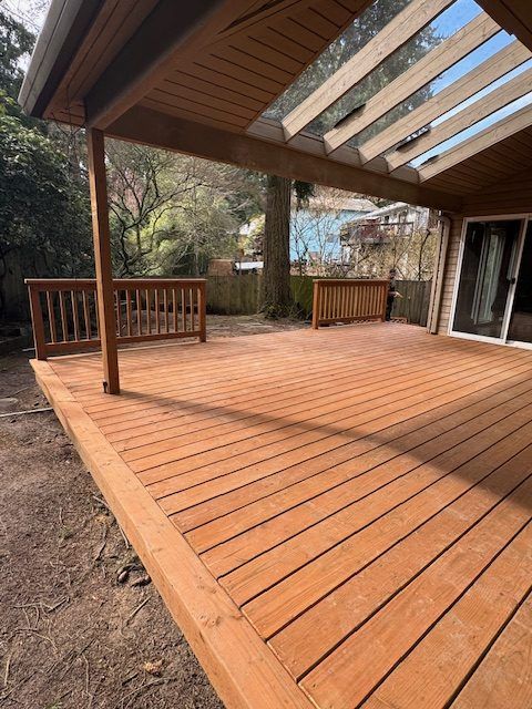 A wooden deck with a covered patio and a bench underneath it.