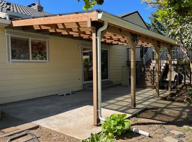 A pergola is being built on the back of a house.