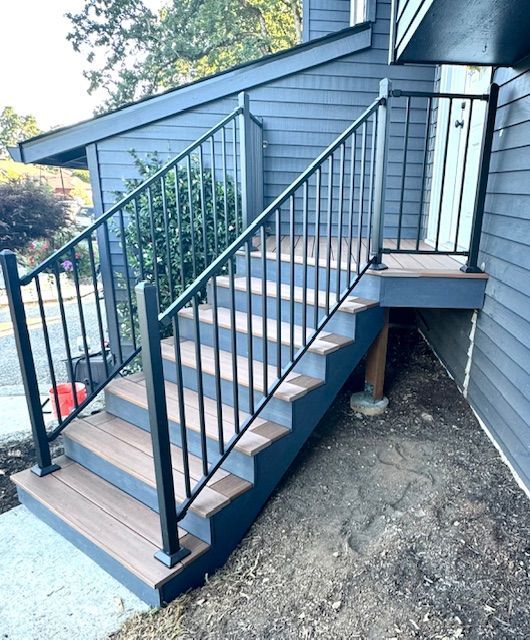 A set of stairs leading up to a house with a metal railing