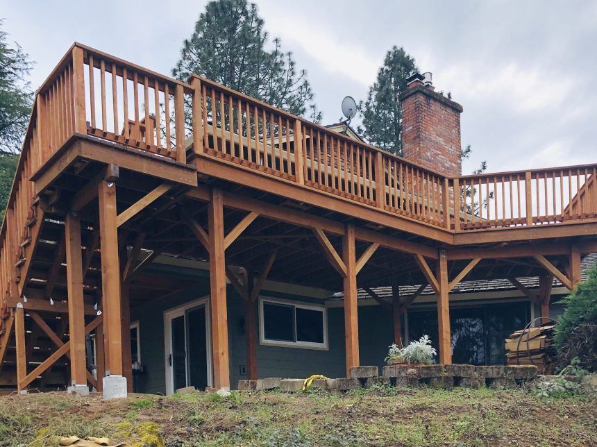 A large wooden deck is sitting on top of a house.