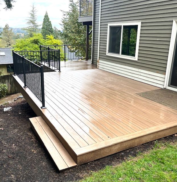 A large wooden deck is sitting in front of a house.