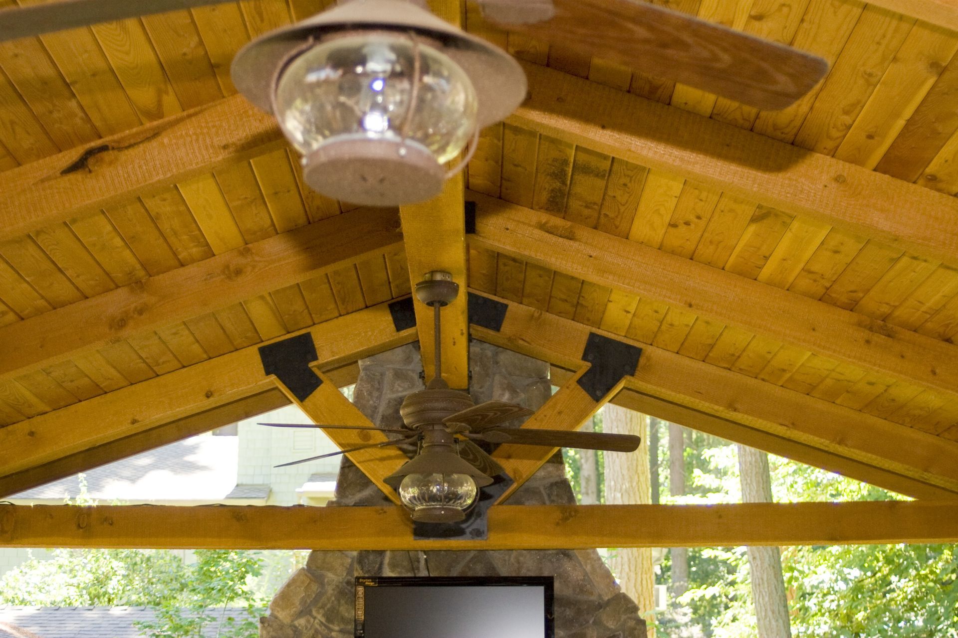 Ceiling fan and light fixture under a wooden pavilion roof