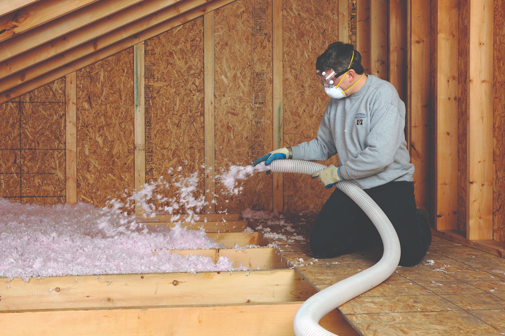 a man is blowing insulation into the attic of a house
