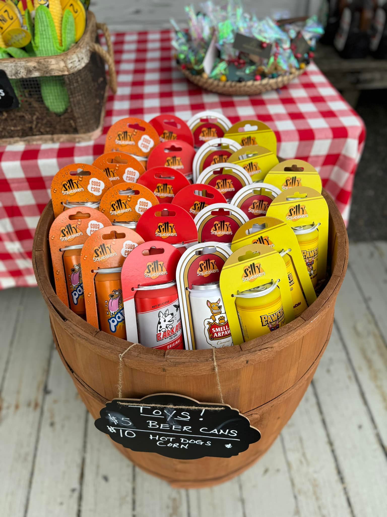 A wooden barrel filled with cans of soda on a table.