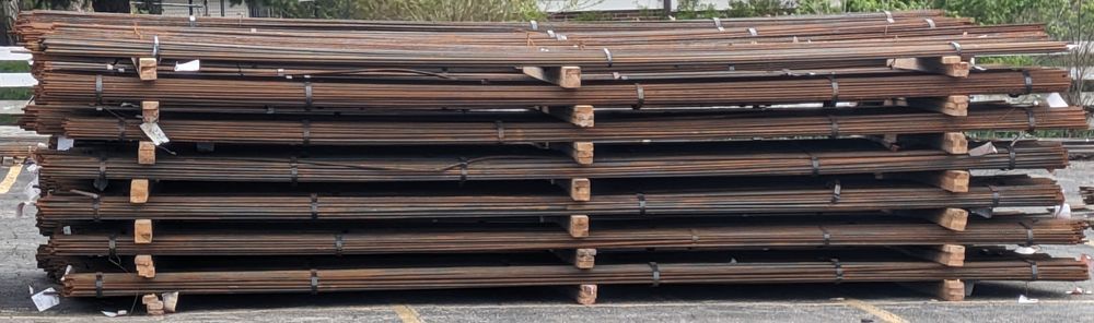 A stack of wooden pallets sitting on top of each other in a parking lot.