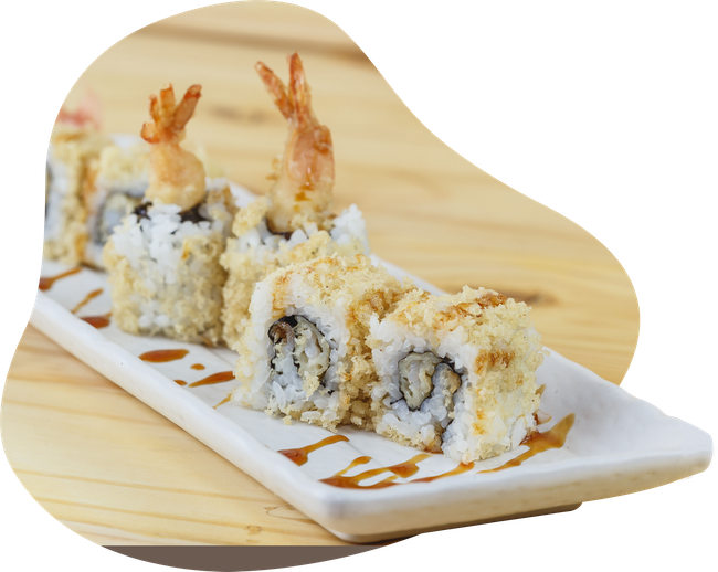 A white plate topped with sushi rolls and shrimp on a wooden table.