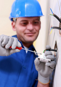man with screwdriver fixing electrical wiring