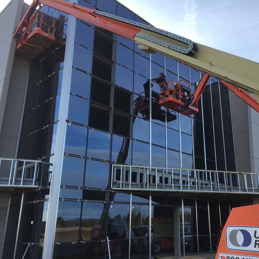 A crane is being used to clean the windows of a building