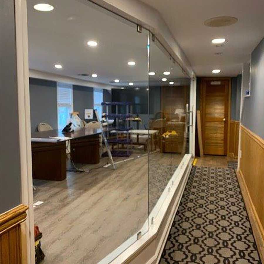 A hallway with a glass wall between two offices.