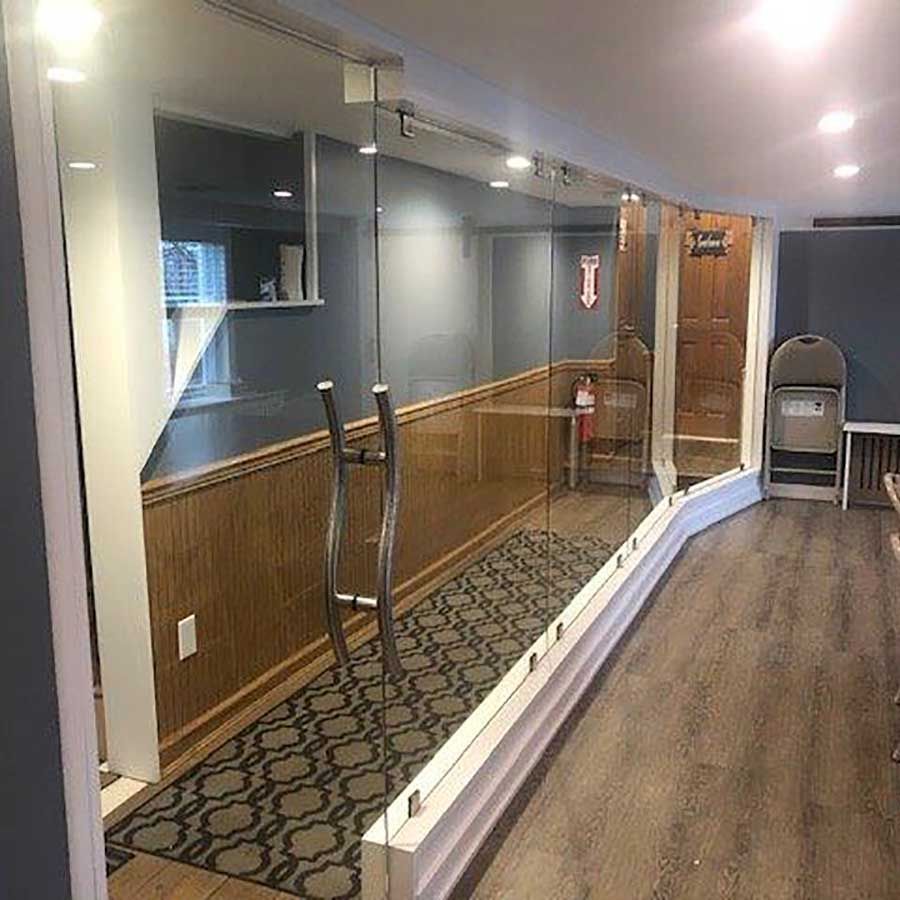 A hallway with a large glass wall between two rooms.