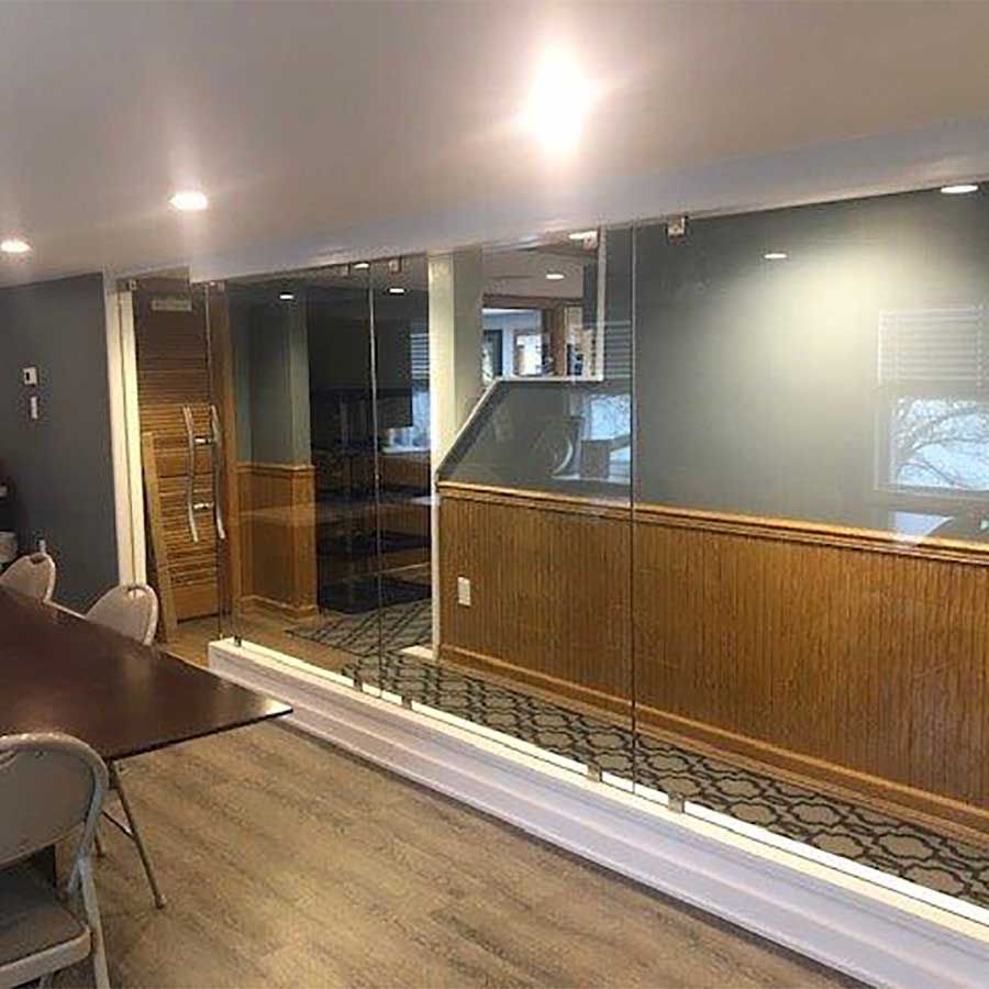 A dining room with a table and chairs and a glass wall.