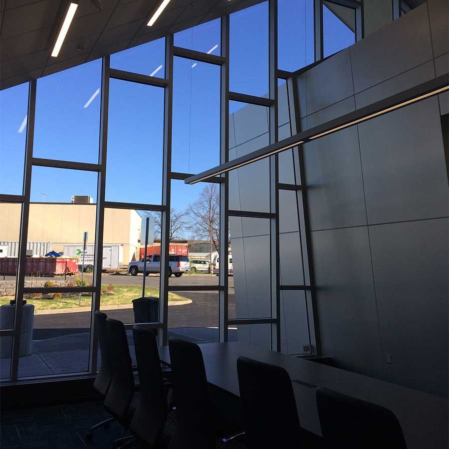 A room with a lot of windows and a table and chairs