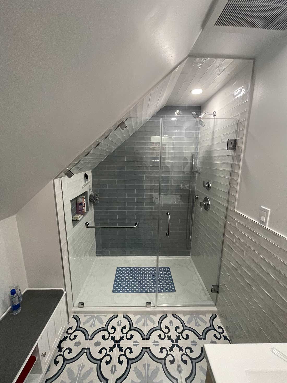 A bathroom with a walk in shower and a tiled floor.