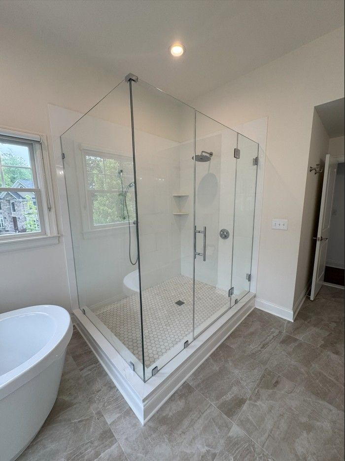 A bathroom with a walk in shower and a bathtub.