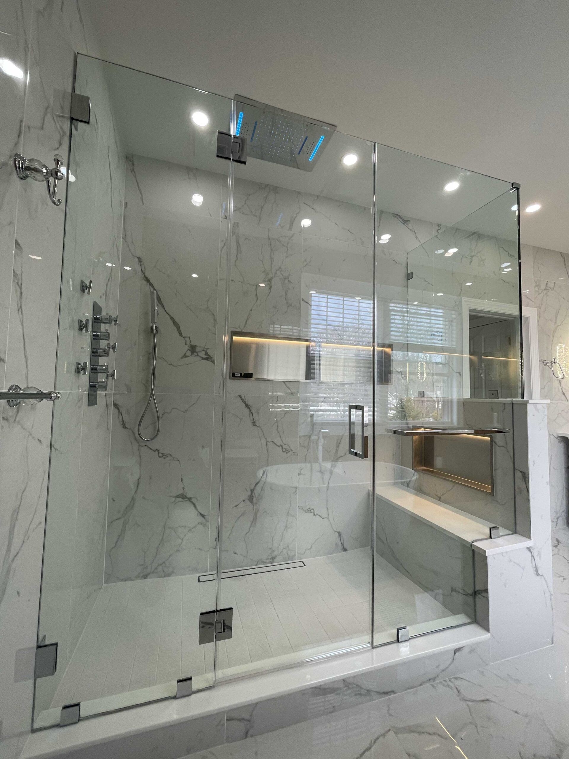 A bathroom with a walk in shower with a glass door.