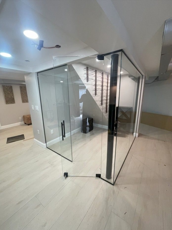 A room with a glass wall and stairs in the background.