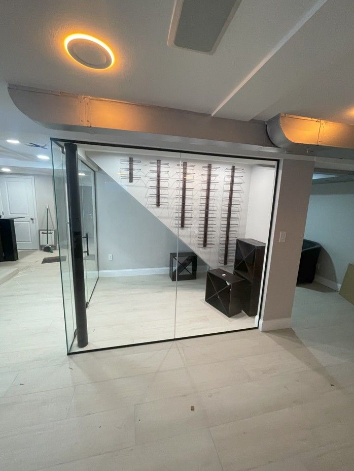 A room with a glass wall and a staircase in the background.