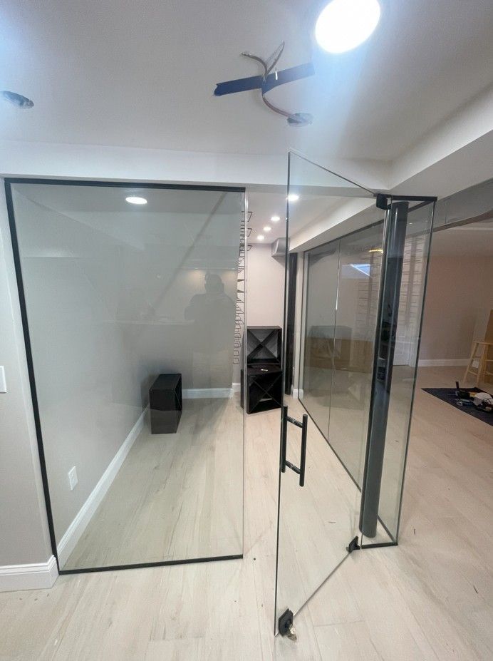 A glass door is open in a room with a ceiling fan.