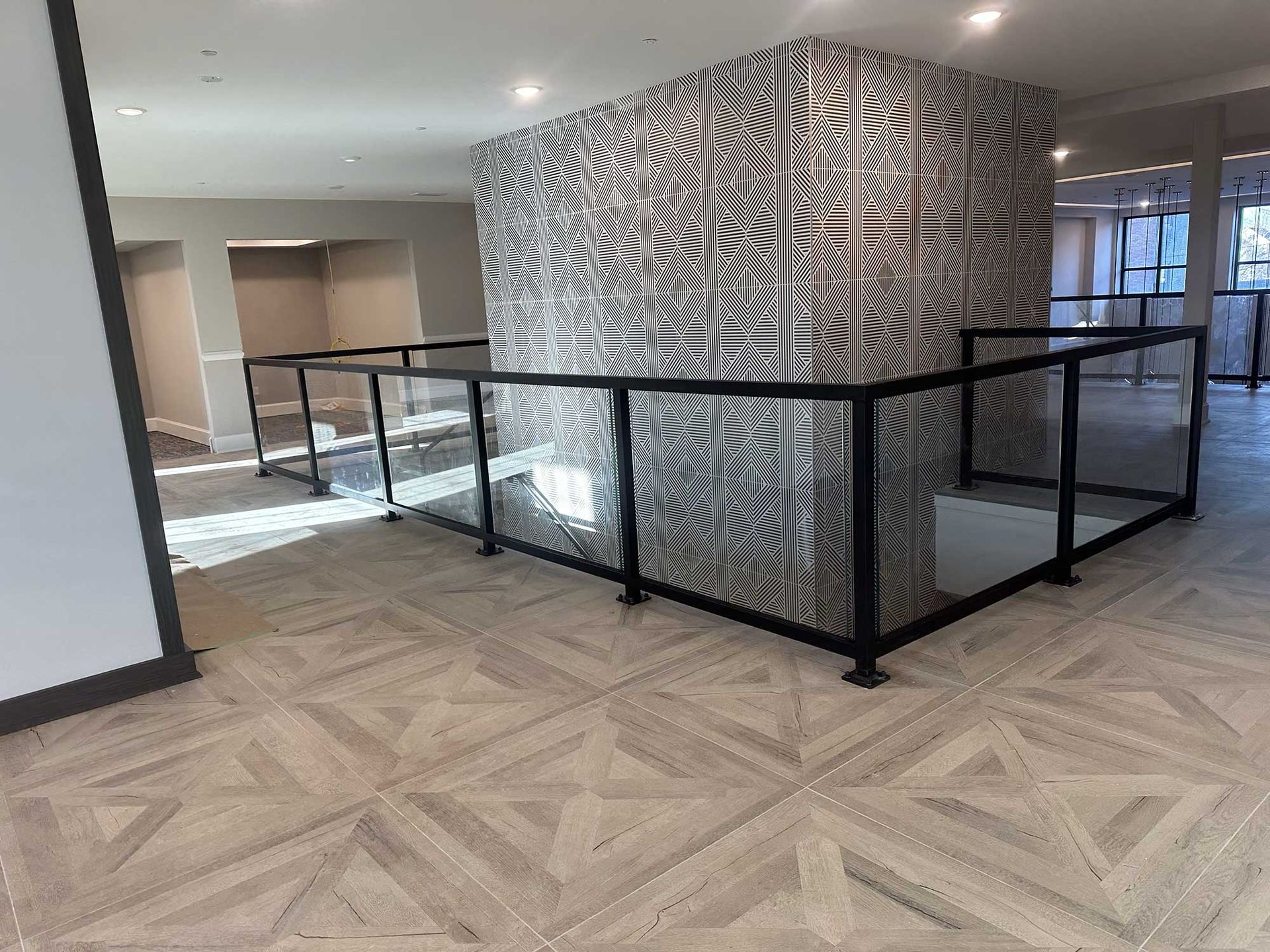 There is a staircase with a glass railing in the middle of the room.