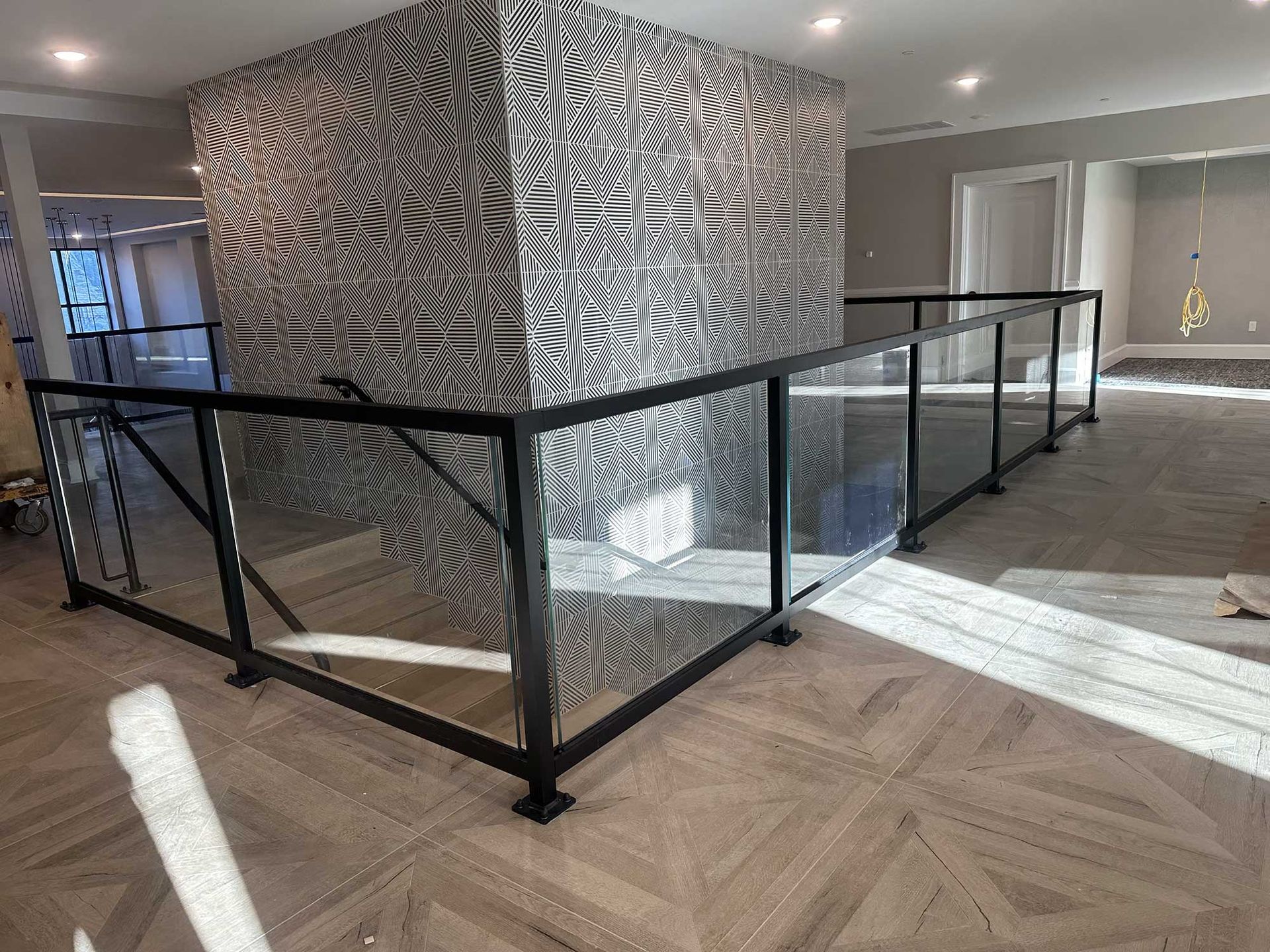 There is a staircase with a glass railing in the middle of the room.