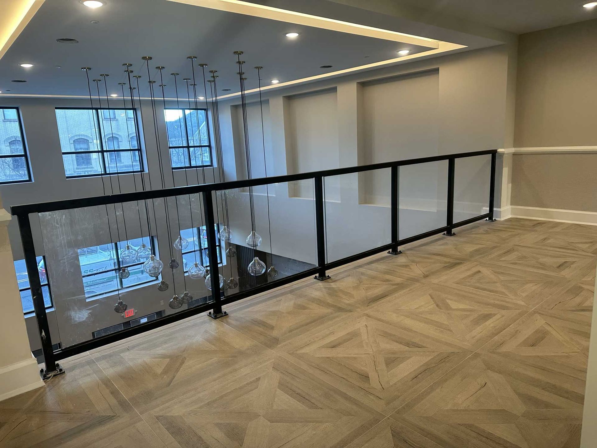 A balcony with a black railing and a wooden floor.