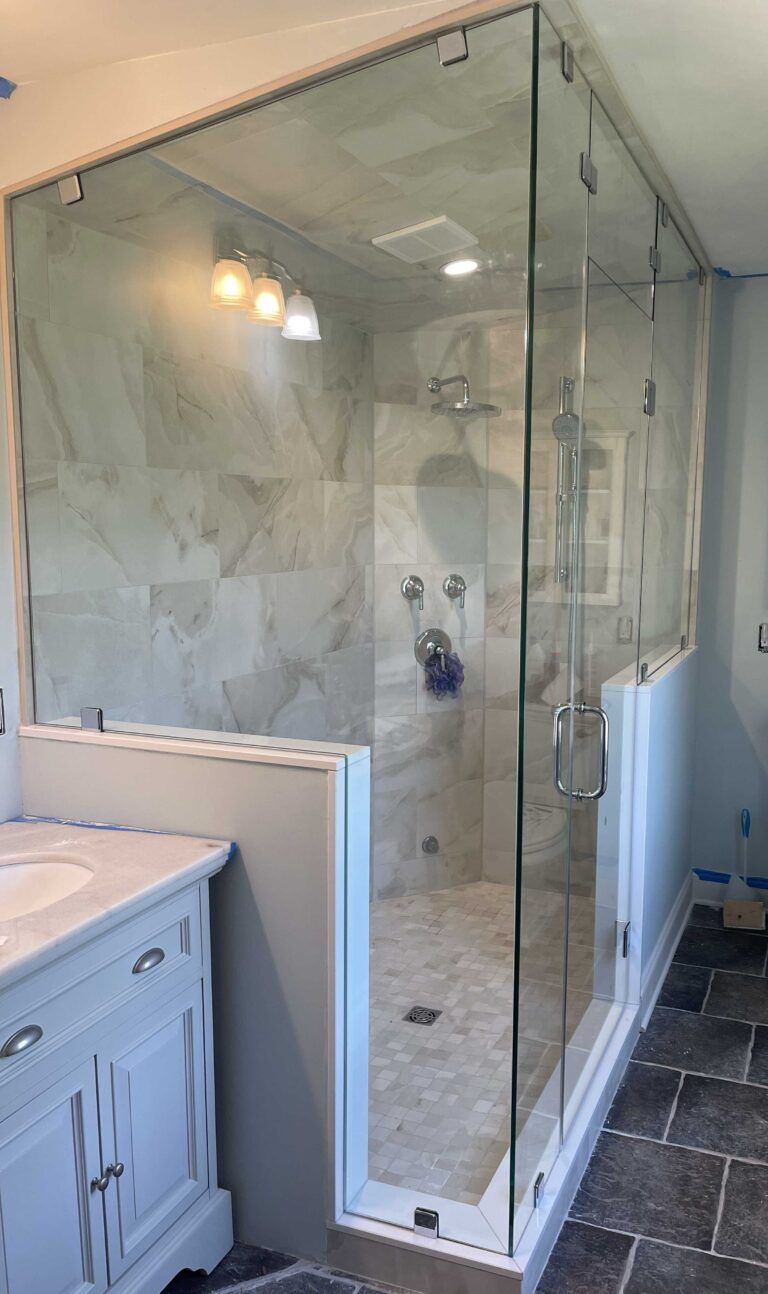 A bathroom with a walk in shower and a sink.