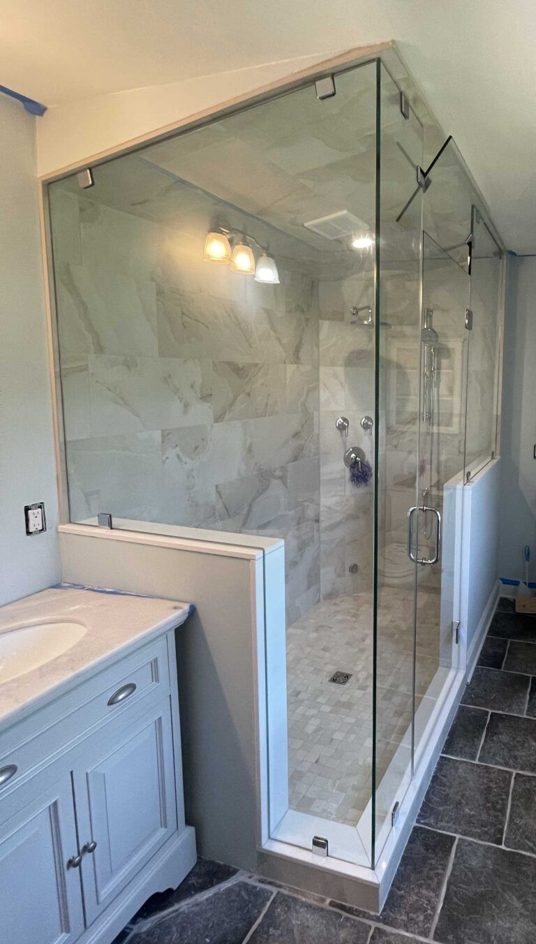 A bathroom with a walk in shower and a sink.