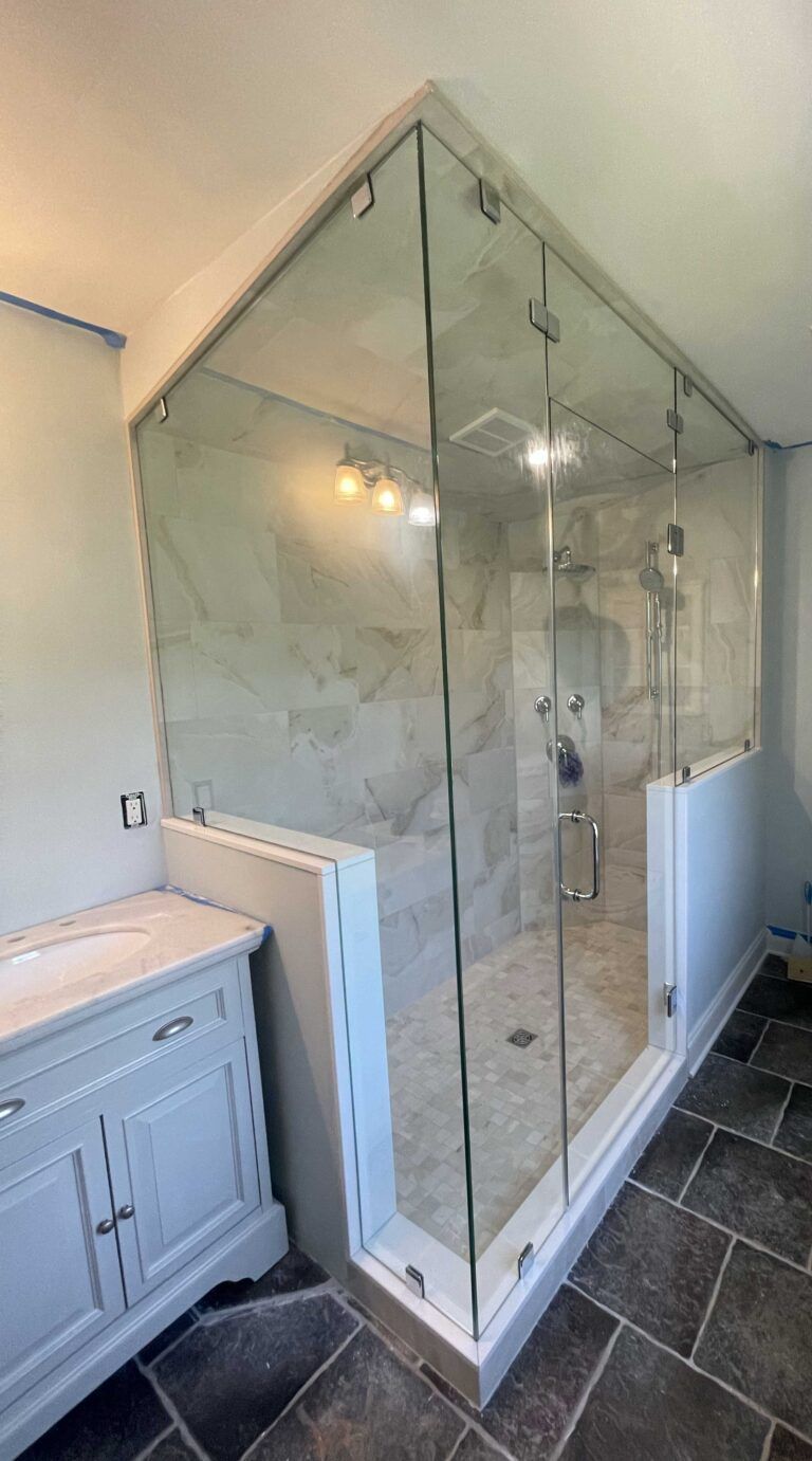 A bathroom with a walk in shower and a sink.