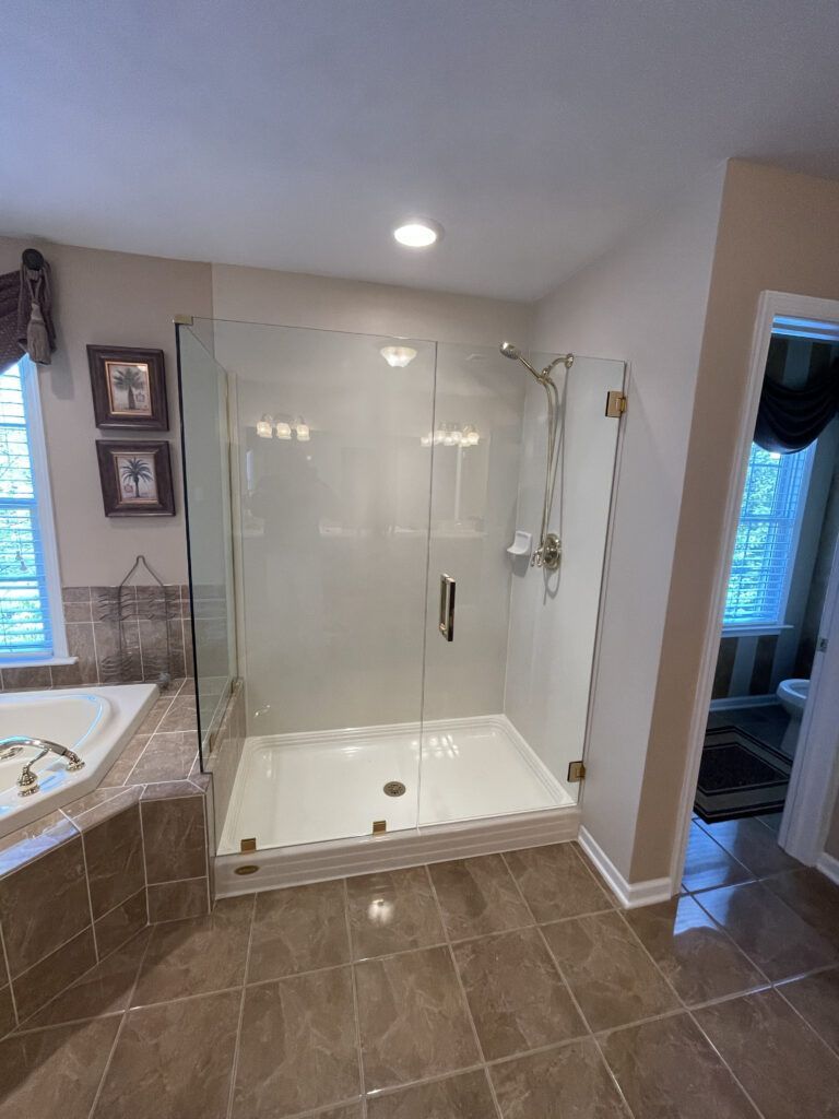 A bathroom with a walk in shower and a bathtub.