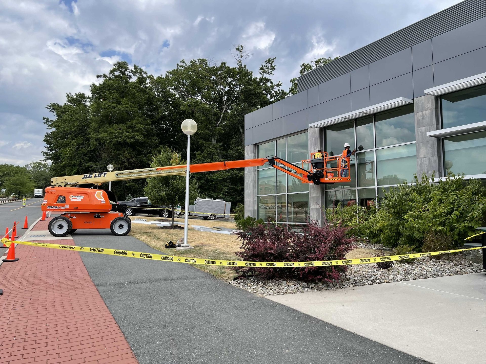 A man in a lift is cleaning the windows of a building.