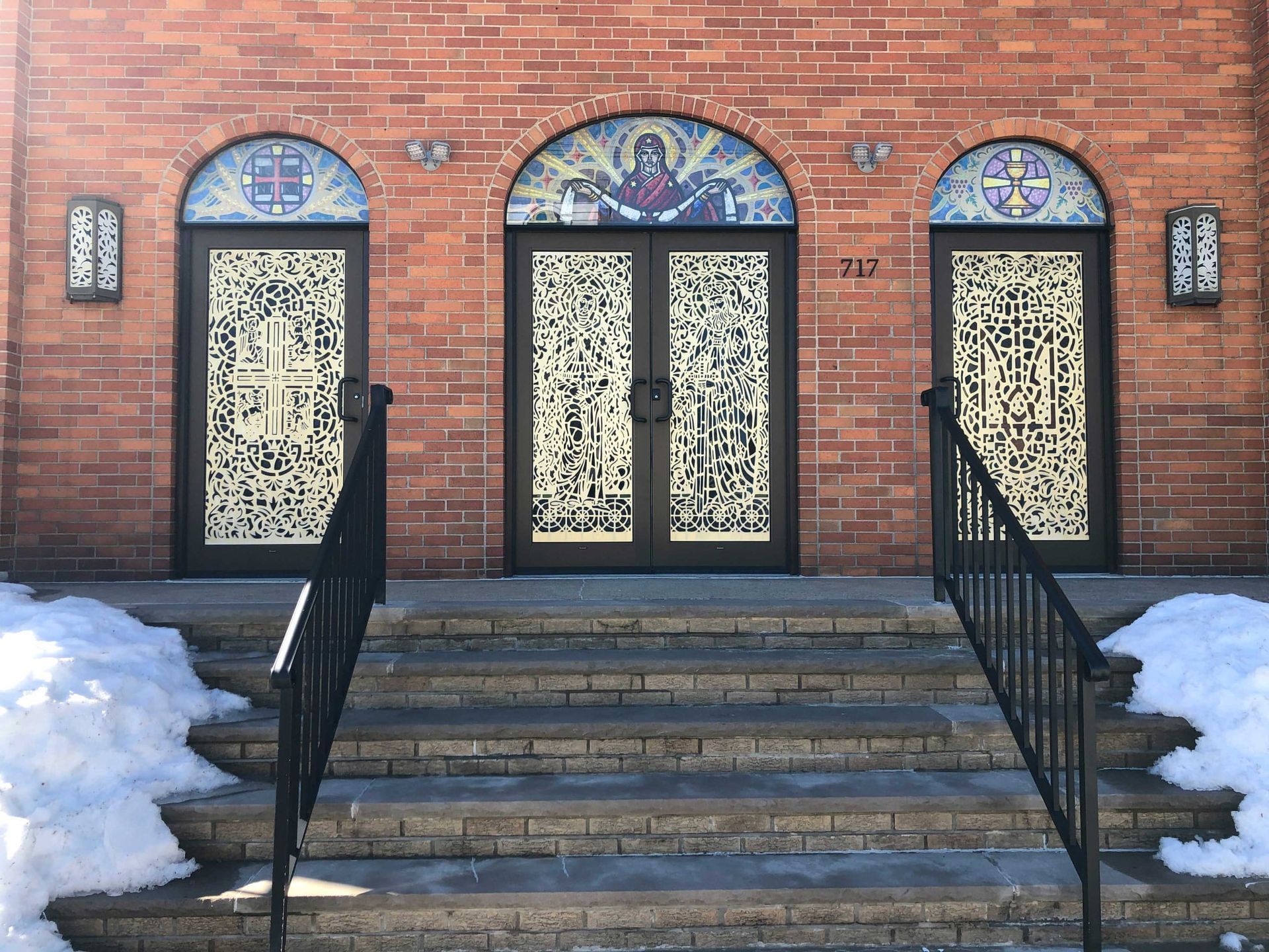 A brick building with stained glass doors and stairs leading up to it.