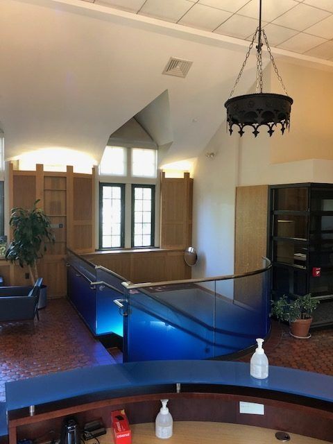 A room with a blue staircase and a chandelier hanging from the ceiling