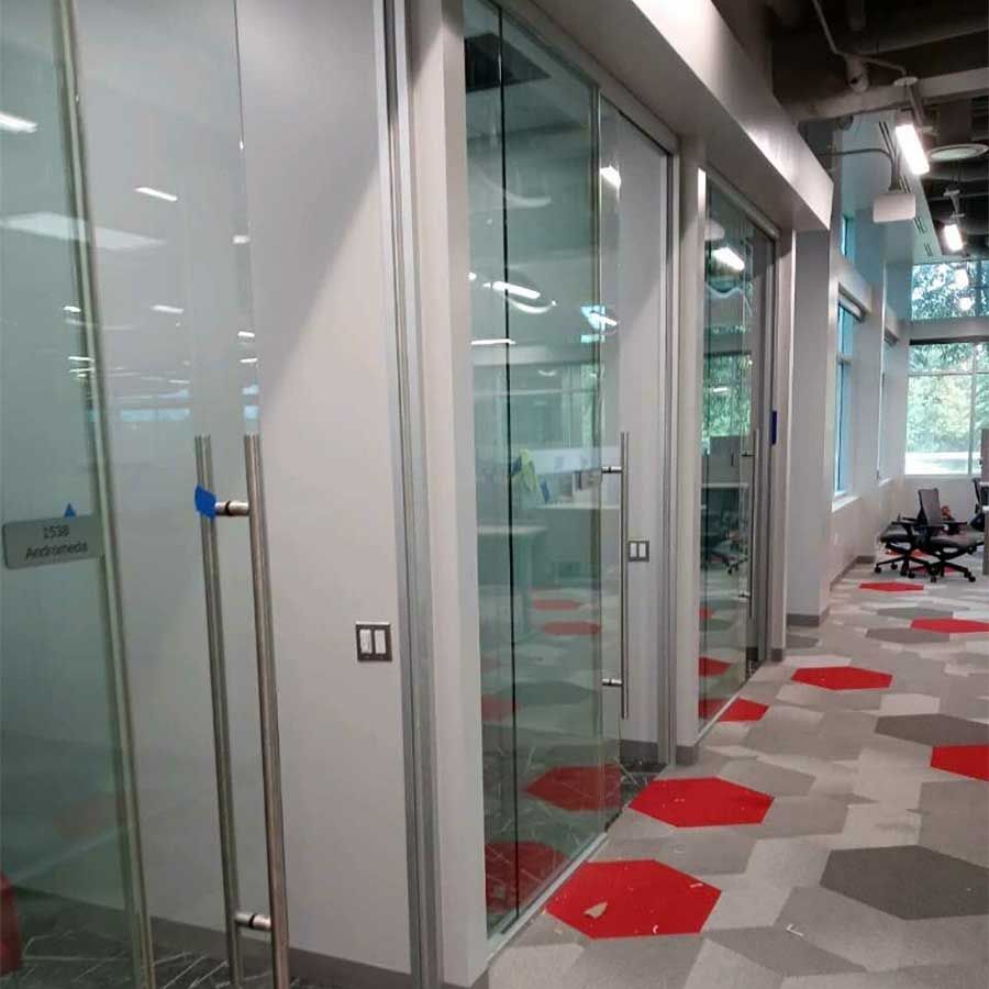 A hallway with glass doors and a carpeted floor