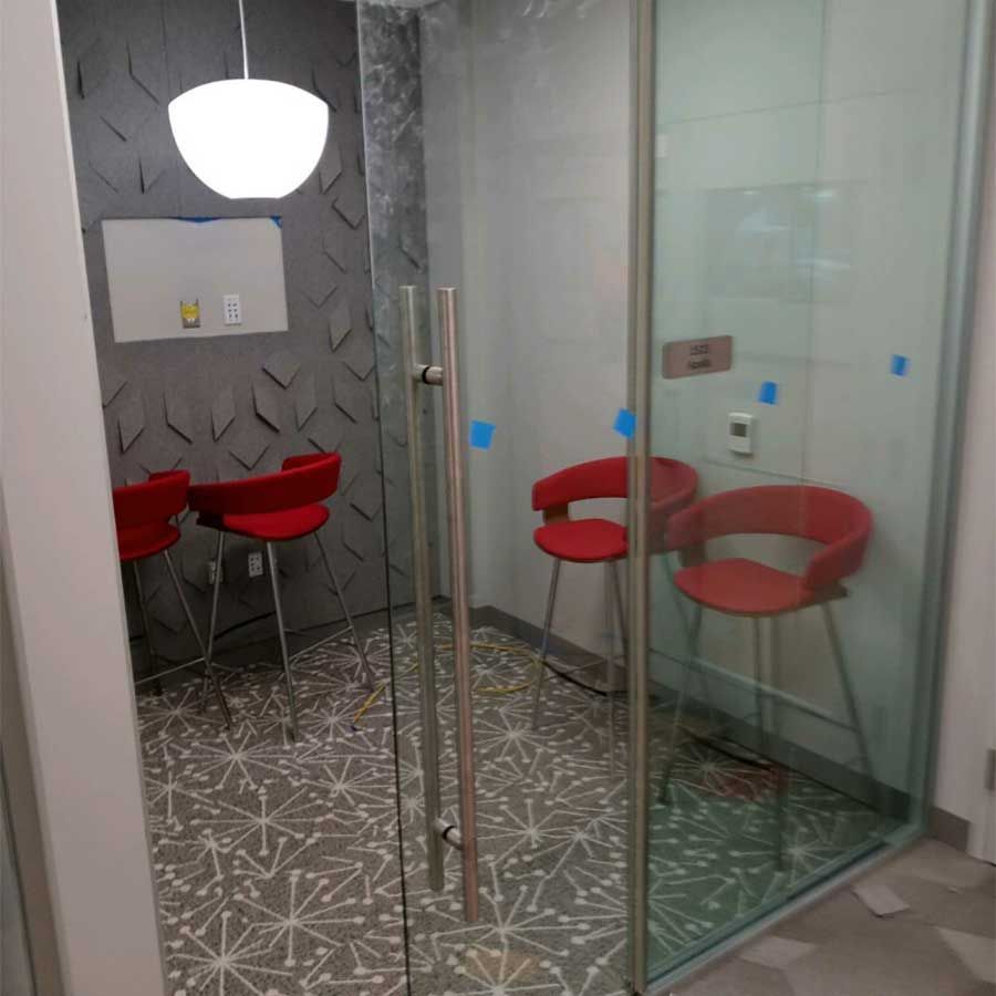 A room with red chairs and a glass door